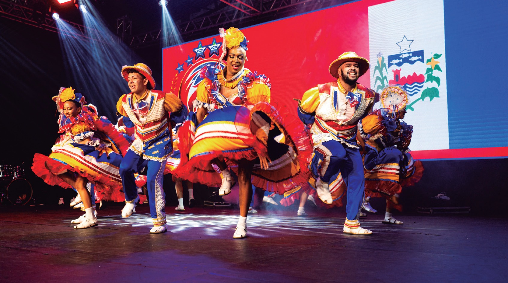 Grupo folclórico se apresenta em palco iluminado durante o Festival de Folclore de Quinta do Sol (Fefosol)
