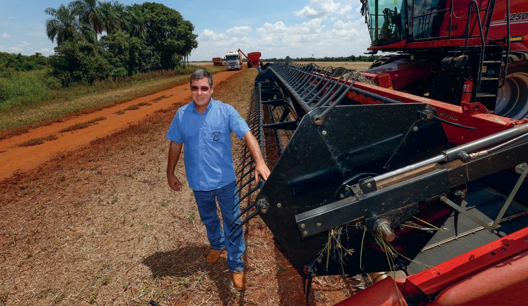 Cooperado Marcos Nunes Zafal&atilde;o caminhando na lavoura ao lado da plataforma de uma colheitadeira