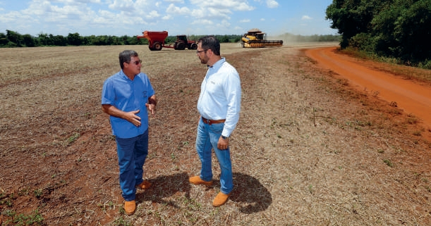 Marcos Nunes Zafal&atilde;o e engenheiro agr&ocirc;nomo conversando em estrada de terra ao lado da lavoura