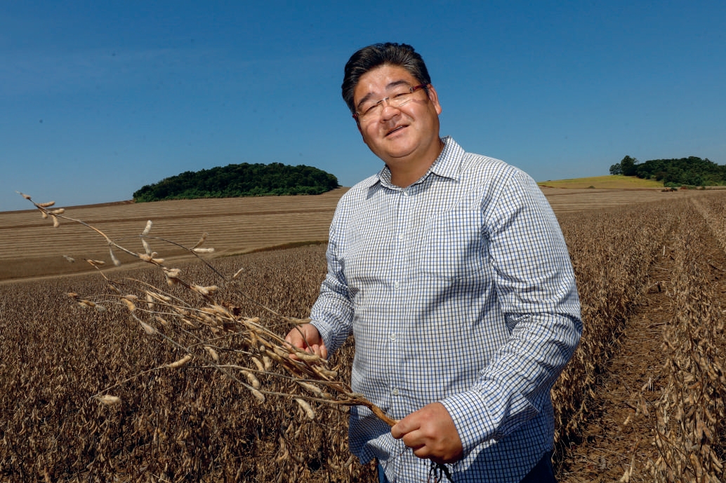 Guy Mitsuyuki Tsumanuma segurando vagem de soja