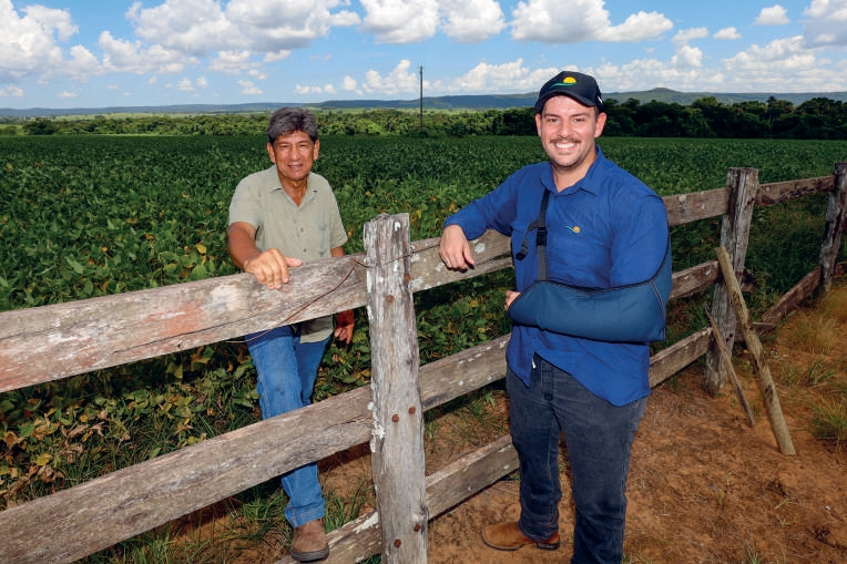 Eder Cristian Queiroz e o pai Edson encostados em uma cerca na propriedade rural
