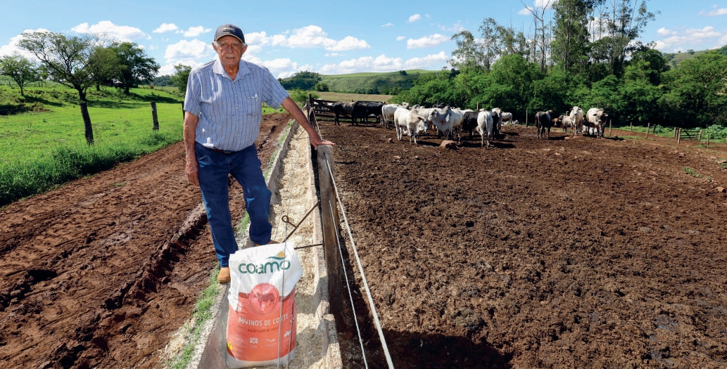 Cooperado Jos&eacute; Carlos Dadalto junto ao cocho alimentando o gado